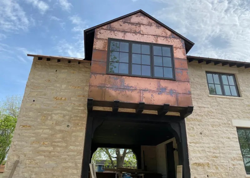 Copper metal panel facade on a stone building for Roof Repair in North Branch
